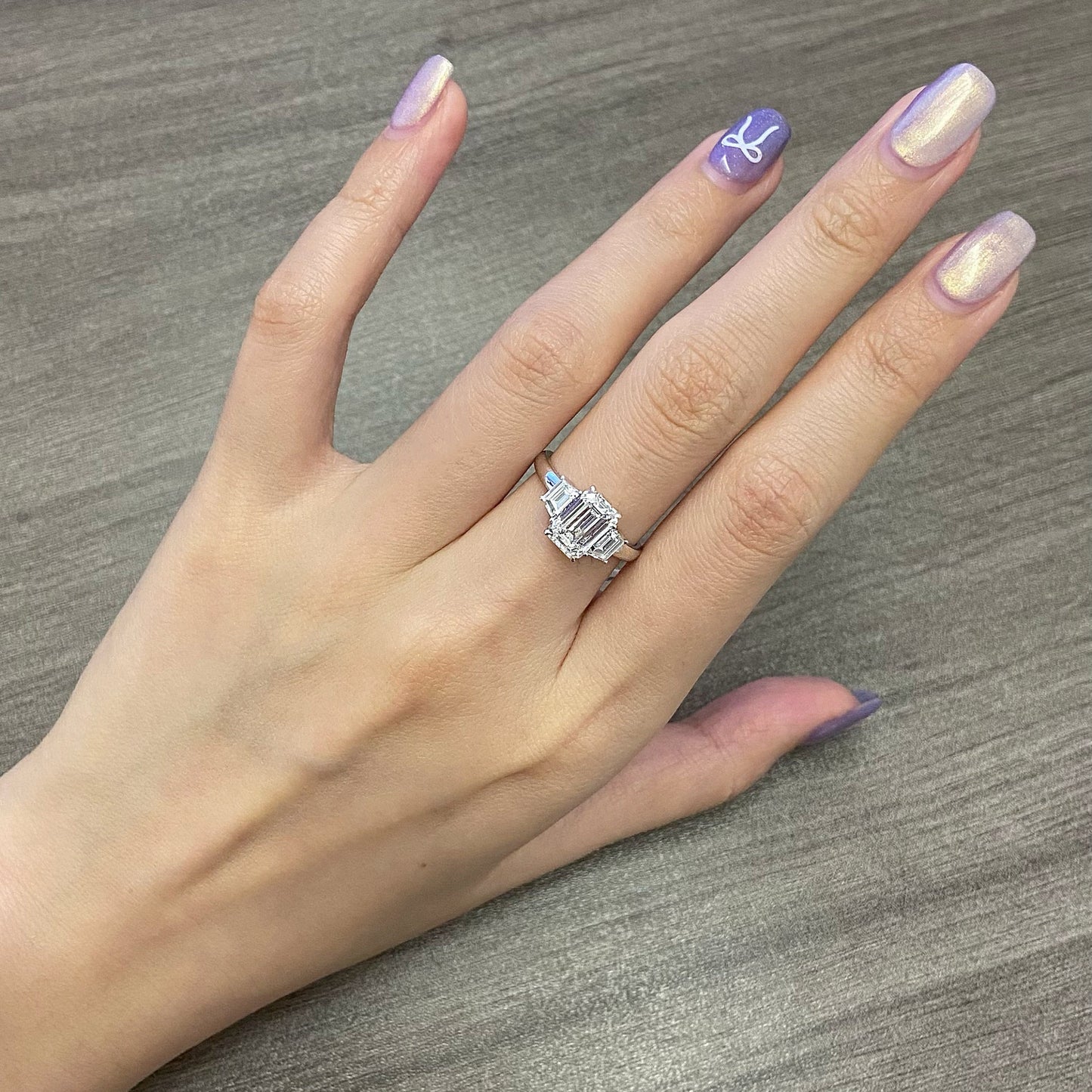 Emerald cut CVD diamond three stone engagement ring with side stones