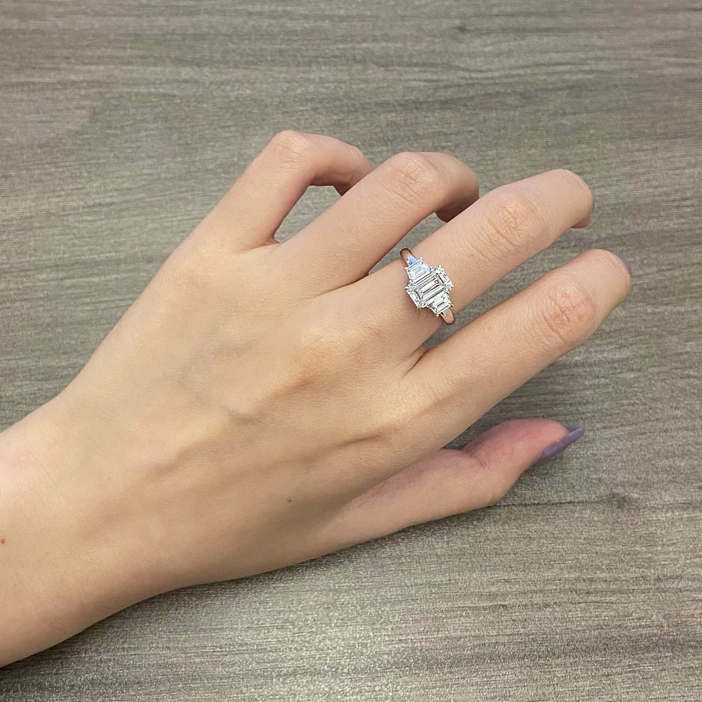 Emerald cut CVD diamond three stone engagement ring with side stones
