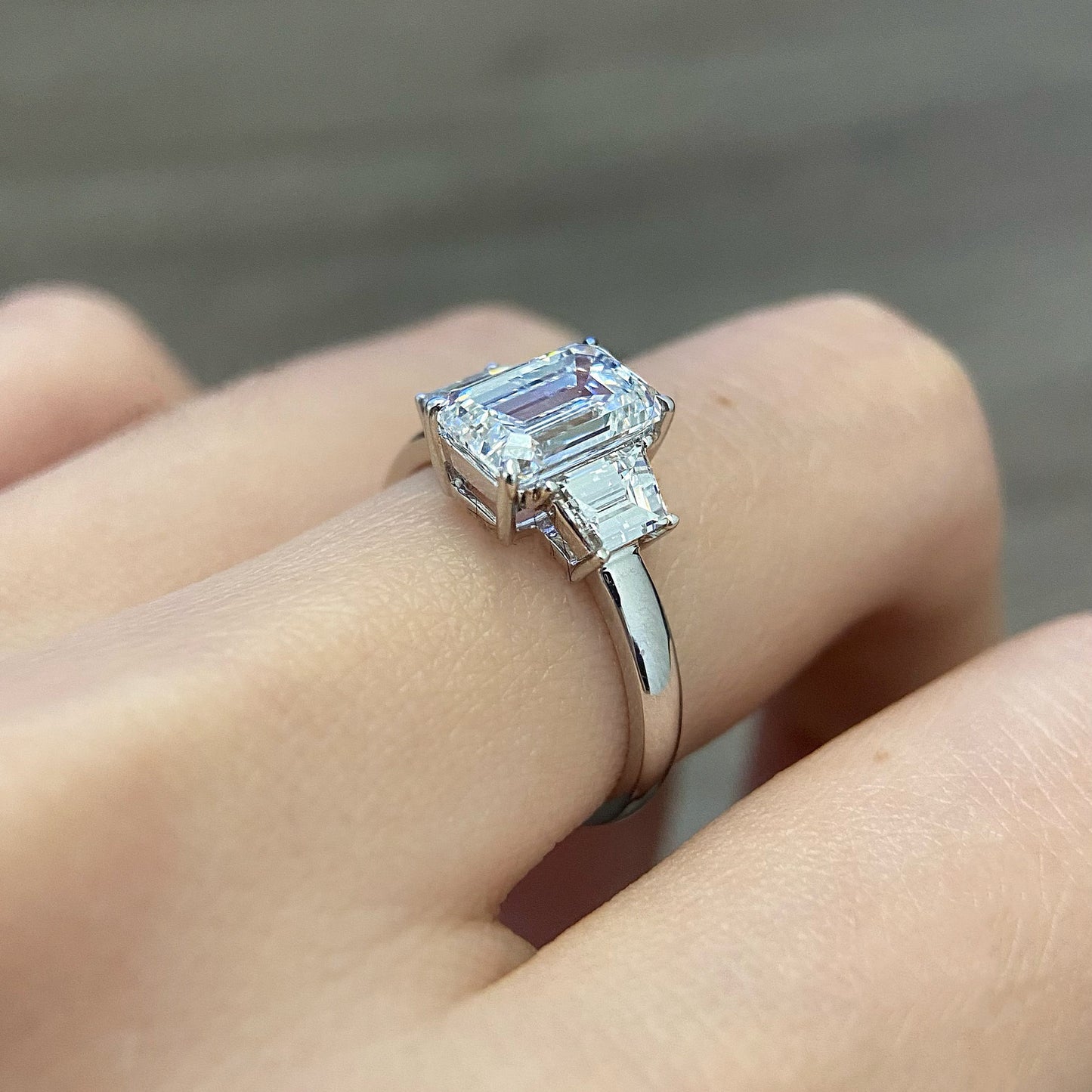 Emerald cut CVD diamond three stone engagement ring with side stones