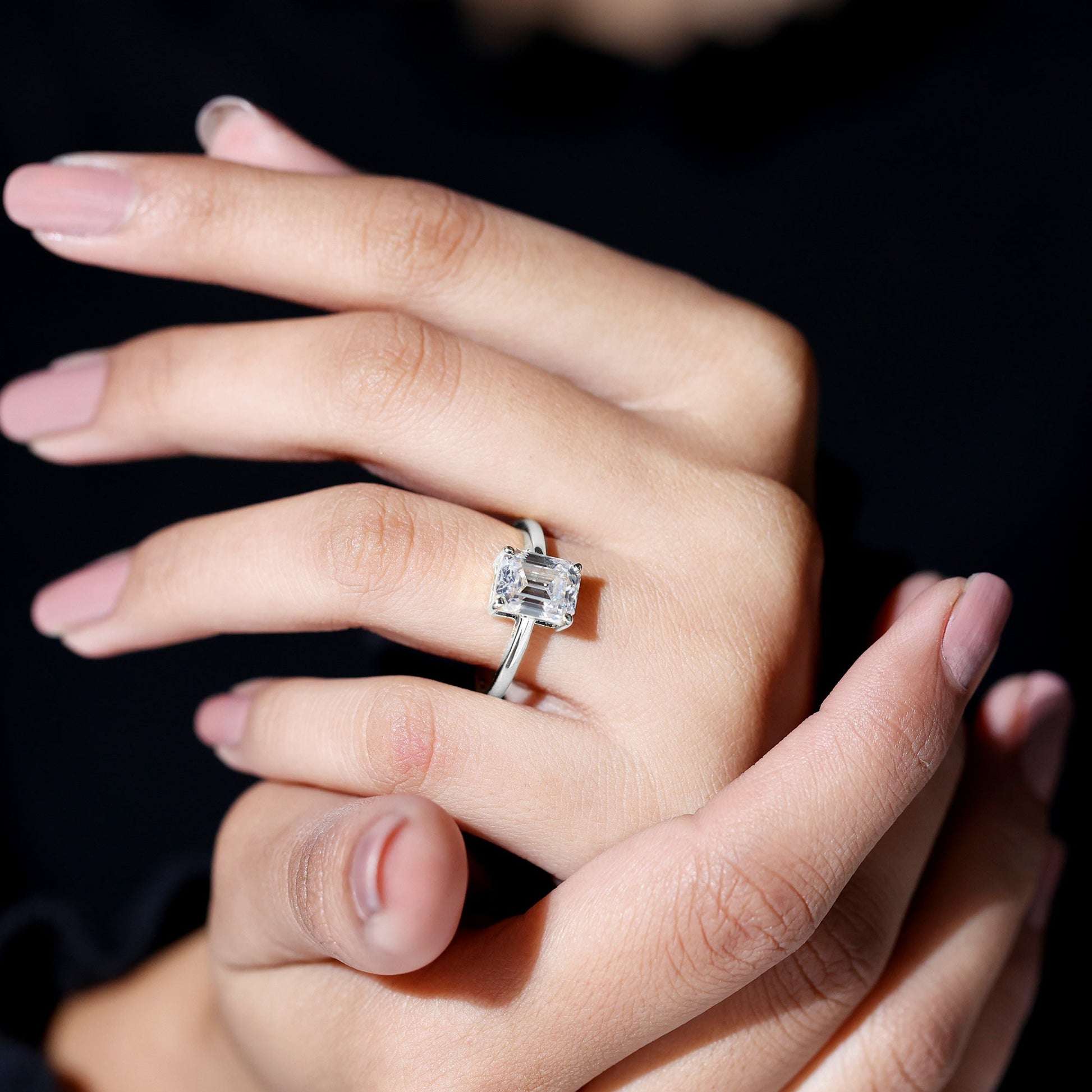 Emerald cut moissanite solitaire engagement ring in elegant setting