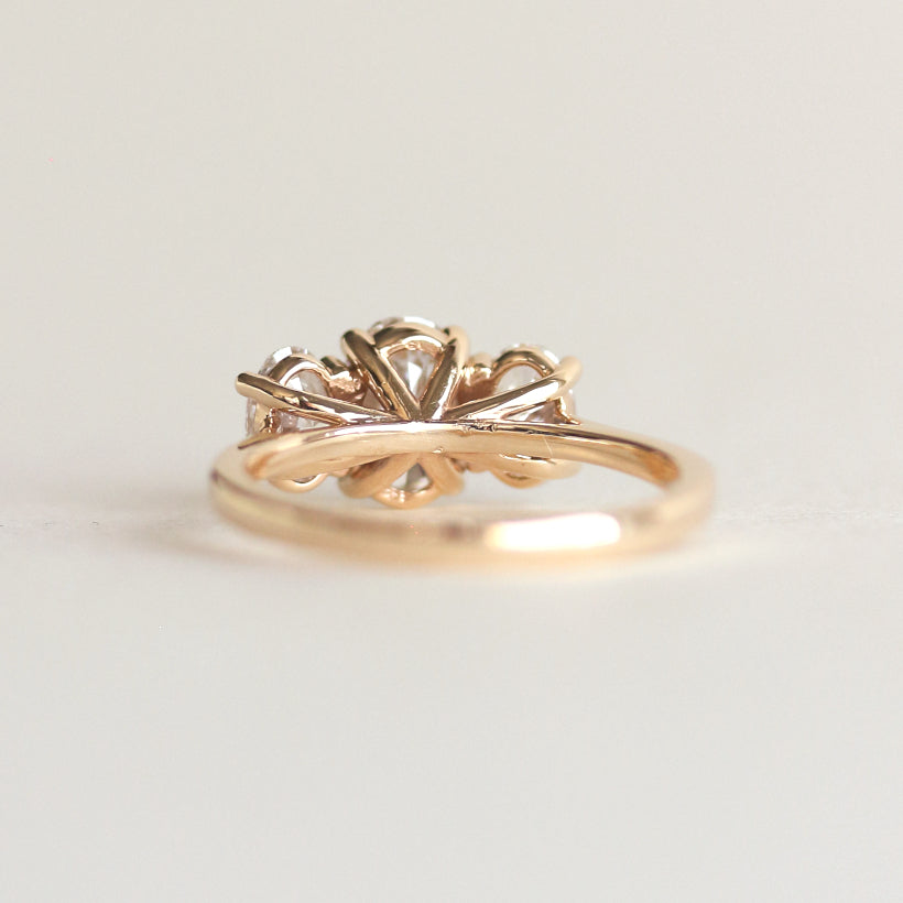 Oval cut CVD lab grown diamond three stone engagement ring with classic prong setting and elegant band