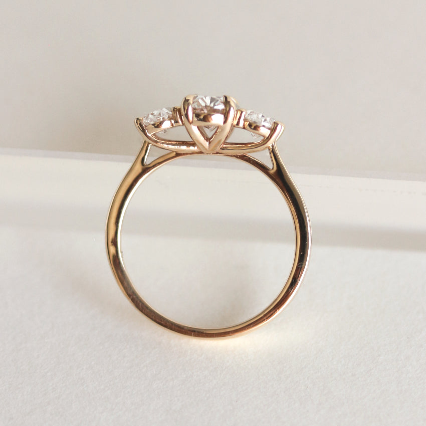 Oval cut CVD lab grown diamond three stone engagement ring with classic prong setting and elegant band