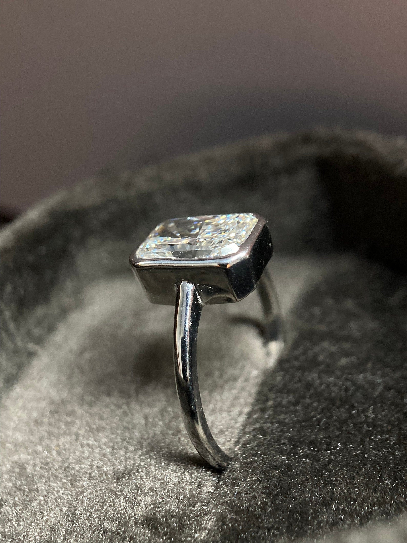 Radiant cut moissanite bezel engagement ring in modern sleek design