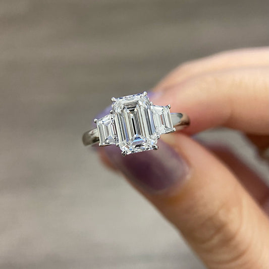 Emerald cut CVD diamond three stone engagement ring with side stones