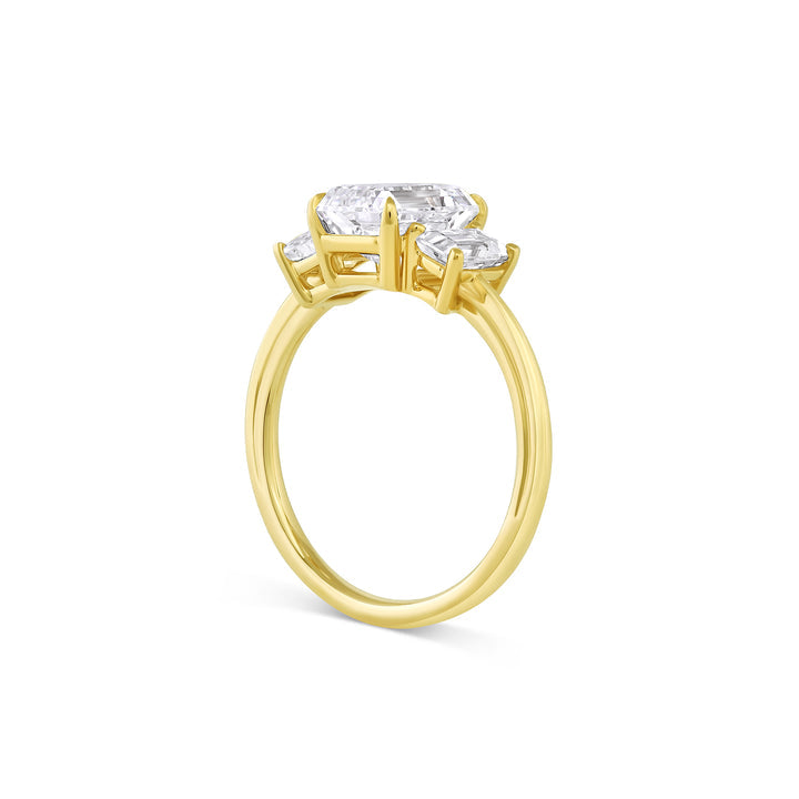 Three stone engagement ring with emerald cut moissanite center