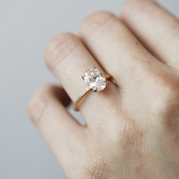 Round moissanite solitaire engagement ring with elegant band