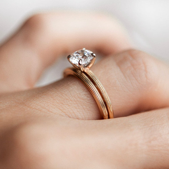 Round moissanite solitaire engagement ring with elegant band