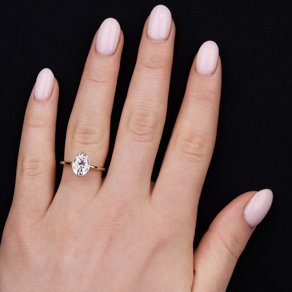 Bezel engagement ring with oval moissanite center stone