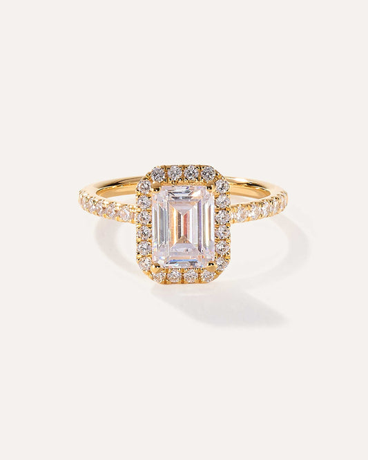 Emerald cut CVD lab grown diamond engagement ring with sparkling halo and pave band in a modern elegant design