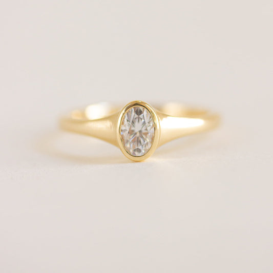 Oval cut CVD lab grown diamond engagement ring in a smooth bezel setting with polished band design