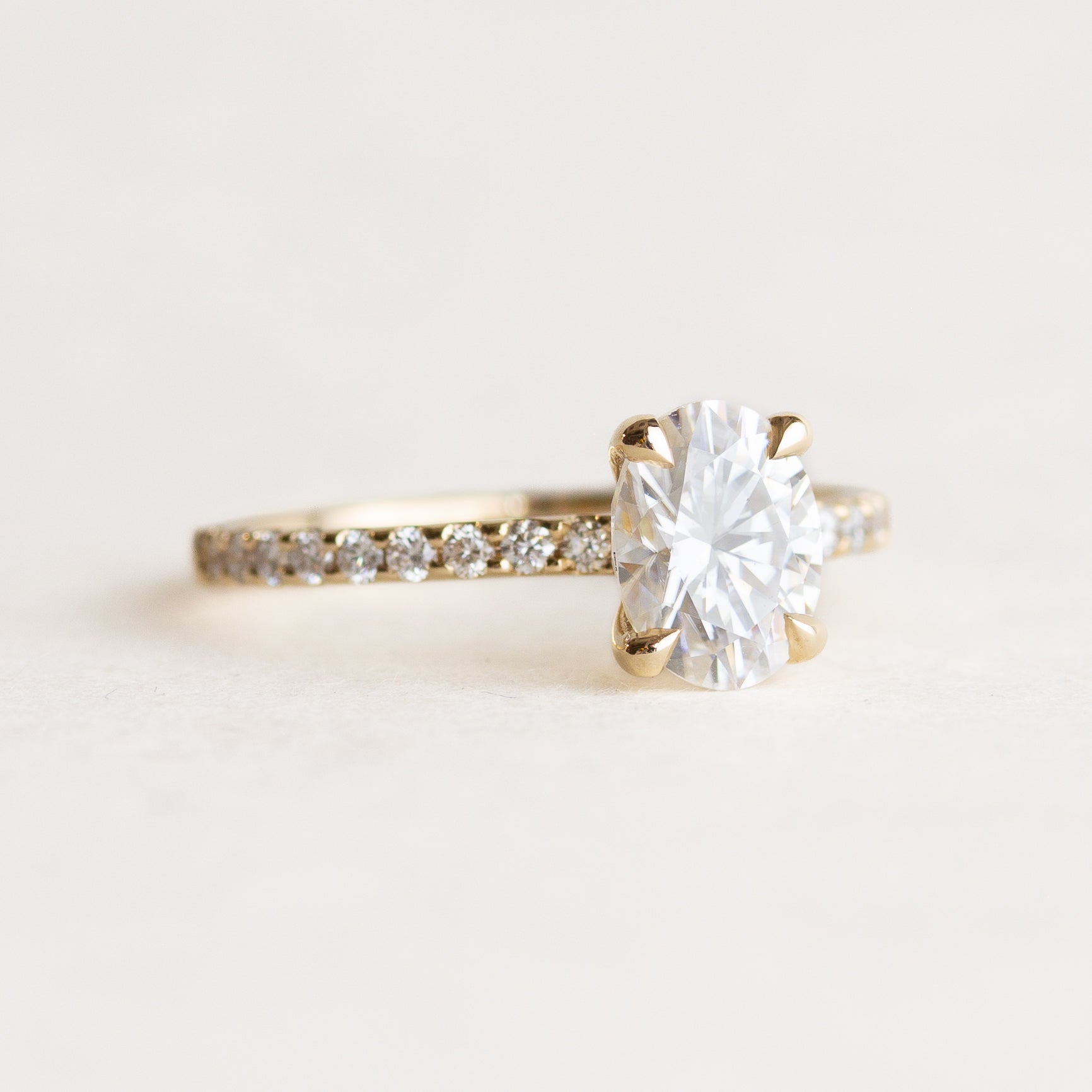 Oval cut CVD lab grown diamond pave engagement ring with slim band adorned with small round diamonds