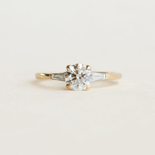 Round cut CVD lab grown diamond three stone engagement ring with polished band and prong-set diamonds