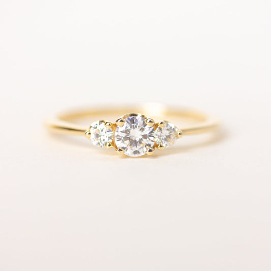 Round cut CVD lab grown diamond three stone engagement ring with classic prong setting and polished band