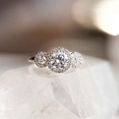 Three stone halo engagement ring with round cut moissanite