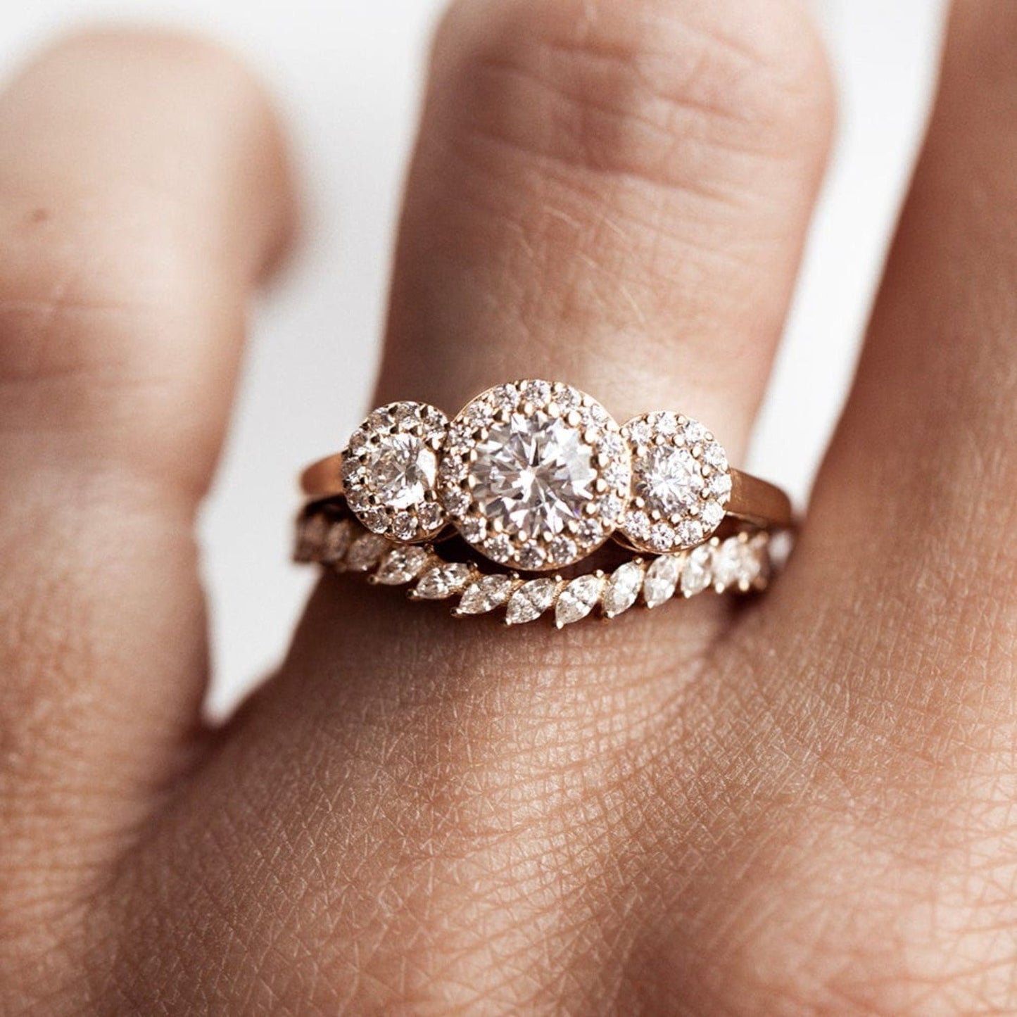 Three stone halo engagement ring with round cut moissanite