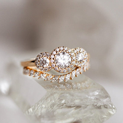 Three stone halo engagement ring with round cut moissanite